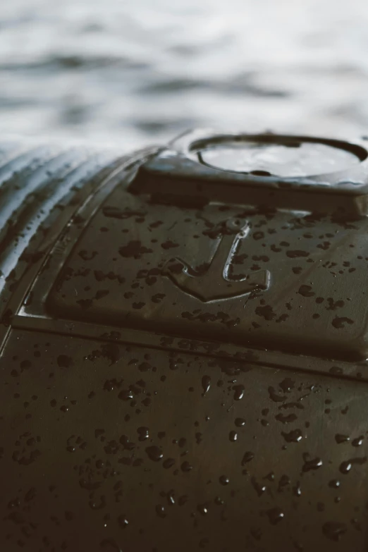a black suitcase sitting on top of a body of water, trending on unsplash, auto-destructive art, spaceship hull texture, ultra detailed rain drops, low - angle shot, markings on robot