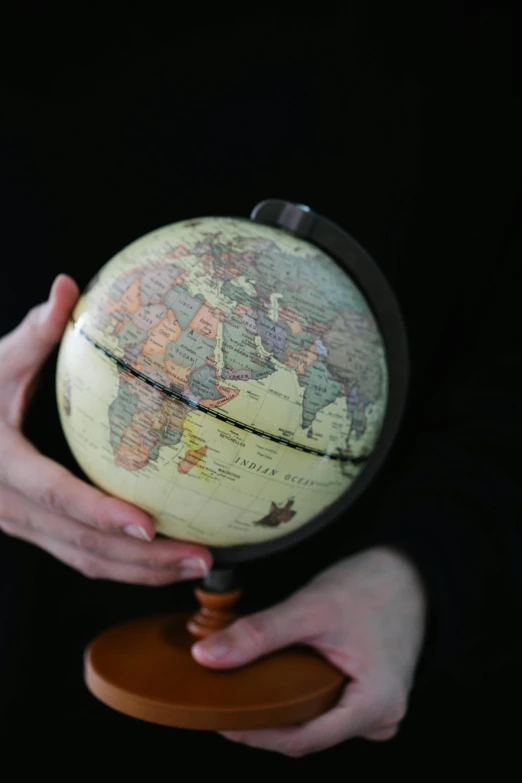 a person holding a globe in their hands, photo taken in 2018, photograph credit: ap, fan favorite, vertical orientation