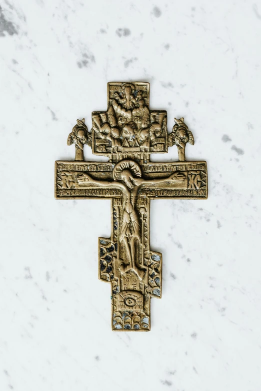 a close up of a cross on a marble surface, bronze material, ornate medieval religious icon, kris kuksi, brass plated