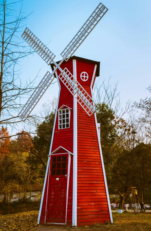 a red windmill sitting on top of a lush green field, woodland village, lynn skordal, winter, square