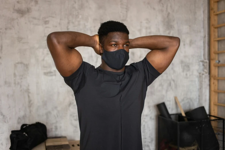 a man in a black shirt and a black mask, wearing fitness gear, ( ( dark skin ) ), indoor picture, without text