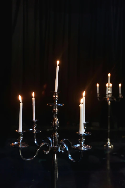 a group of candles sitting on top of a table, baroque, in a pitch black room, gleaming silver, featuring rhodium wires, mid morning lighting