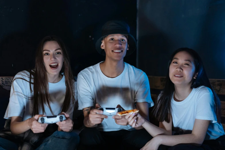 three people sitting on a couch playing a video game, a portrait, pexels contest winner, in front of a black background, teenagers, promotional image, looking up at camera