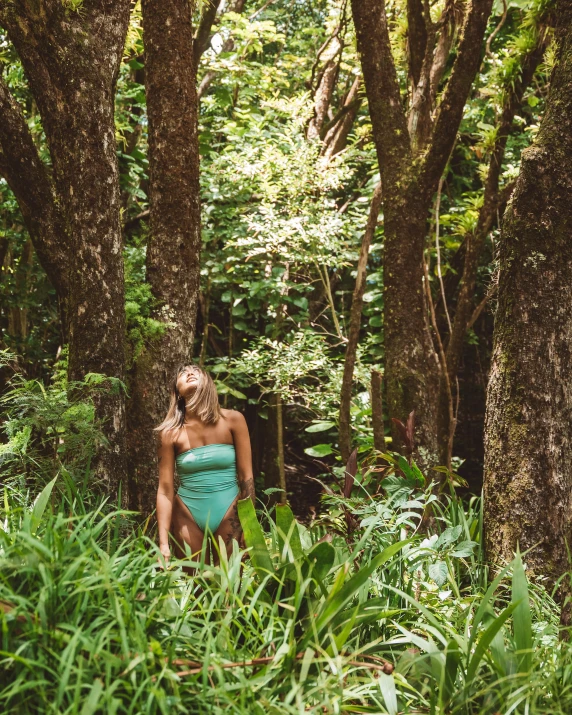 a woman walking through a lush green forest, inspired by Elsa Bleda, unsplash, closed swimsuit, kauai, low quality photo, multiple stories