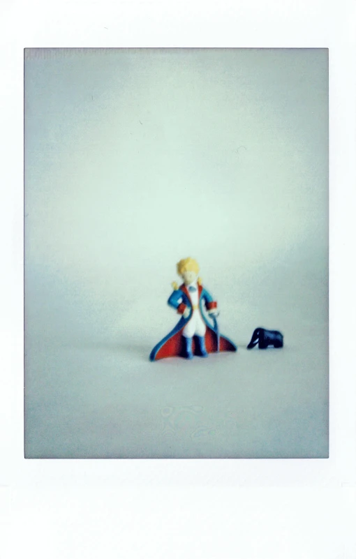a couple of figurines sitting on top of a snow covered ground, a polaroid photo, by Penelope Beaton, conceptual art, dressed like napoleon bonaparte, portrait of magical blond prince, 1 9 8 9 disney, minifigure