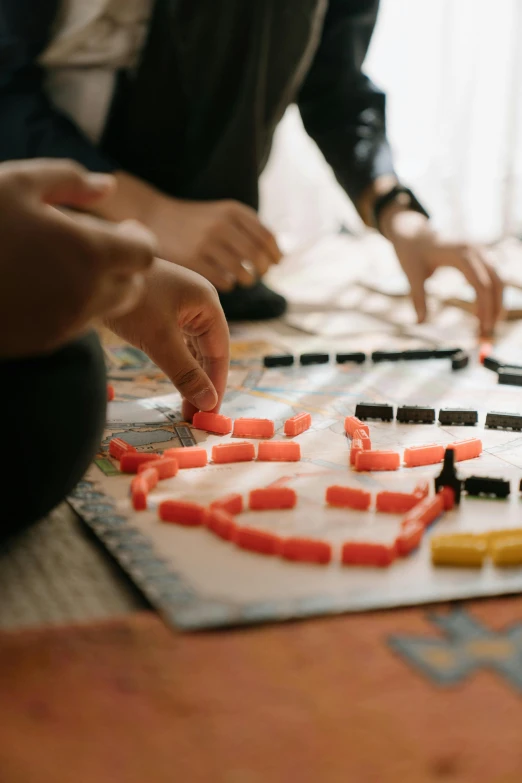 a group of people playing a board game, by Jessie Algie, pexels contest winner, visual art, abstract claymation, square, at home, shot with canon eoa 6 d mark ii