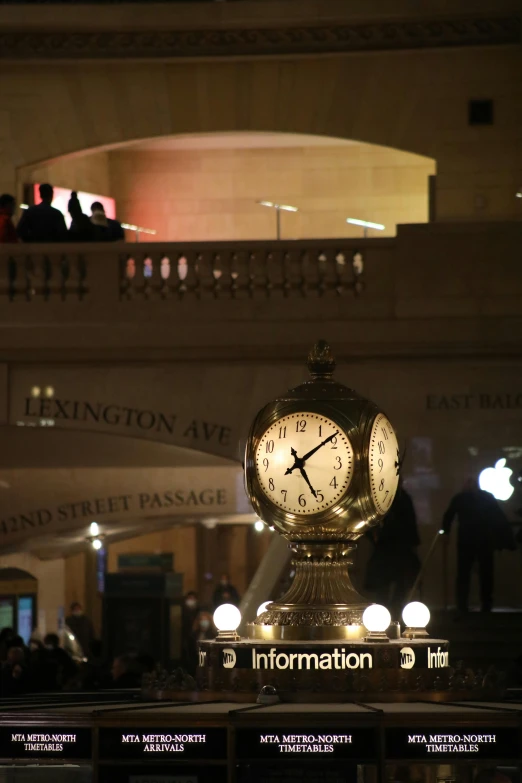 a large clock sitting in the middle of a building, in the spotlight, people watching around, decorations, on a marble pedestal