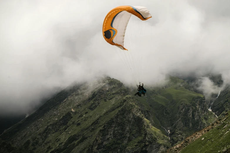 a person paragliding in the mountains on a cloudy day, pexels contest winner, figuration libre, 9 9 designs, 4 k, lpoty, summer weather