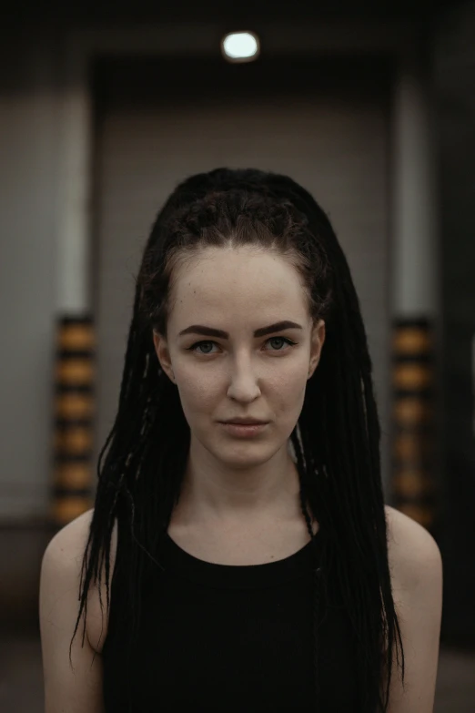 a woman with long black hair standing in a room, pexels contest winner, antipodeans, dreadlock black hair, serious faces, headshot, pale skin