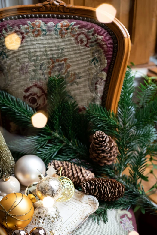 a teddy bear sitting on top of a chair, a still life, inspired by Ernest William Christmas, pexels, baroque, fir trees, gold embroidery, medium close up, evergreen