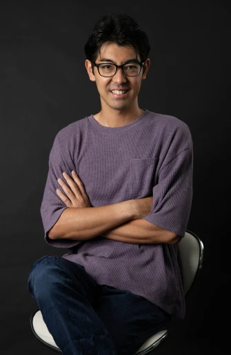 a man sitting on a chair with his arms crossed, a character portrait, inspired by Tadashi Nakayama, unsplash, wearing purple undershirt, man with glasses, graduation photo, joe taslim