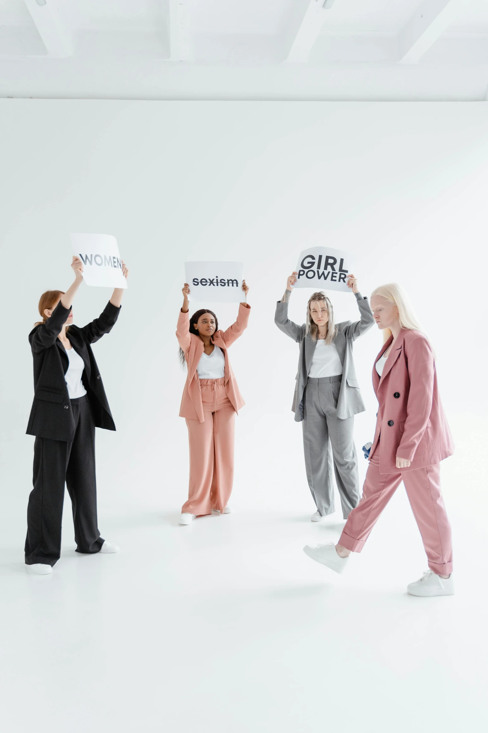 a group of business people holding up signs, trending on pexels, feminist art, full body with costume, on a gray background, girls, ( ( theatrical ) )