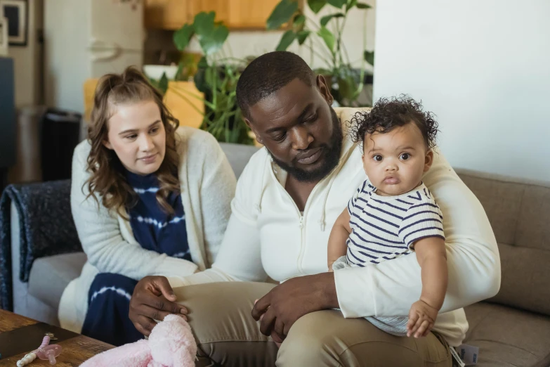 a man and woman sitting on a couch with a baby, pexels, any racial background, portrait image, worried, instagram picture