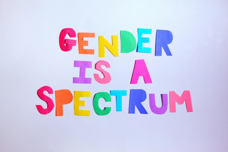 a sign that says gender is a spectrum, pexels, text on paper, adafruit, multi colour, a human
