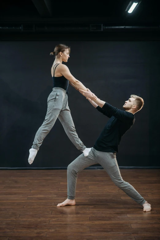 a man and woman doing a handstand in a dance studio, a portrait, trending on unsplash, anna nikonova aka newmilky, animation, hyperrealistic”, set photo