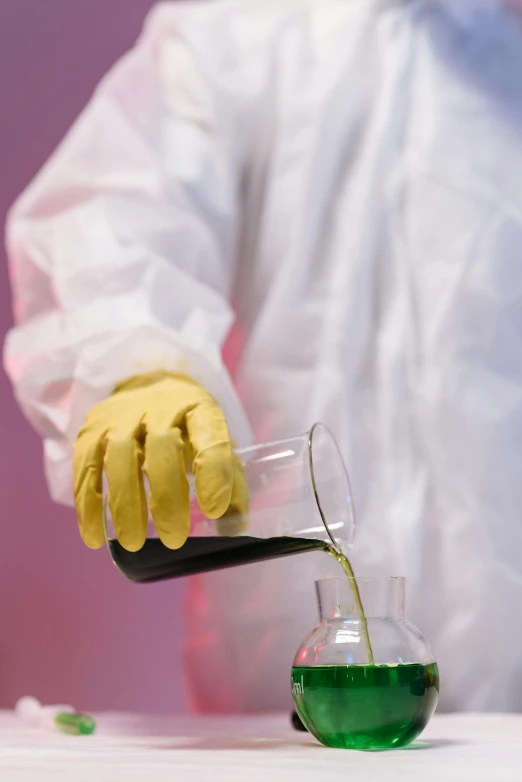 a person in a lab coat pouring liquid into a flask, yellow latex gloves, vantablack gi, upclose, fabrics