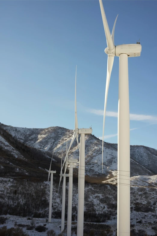 a group of wind turbines sitting on top of a snow covered hillside, arabesque, slide show, las vegas, #green, clean design