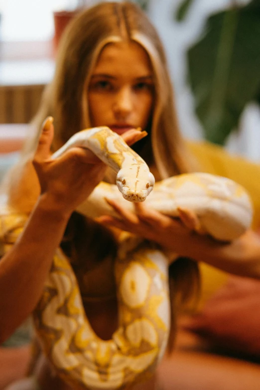 a woman holding a snake in her hands, trending on pexels, 2 animals, intense albino, calmly conversing 8k, 1 6 years old