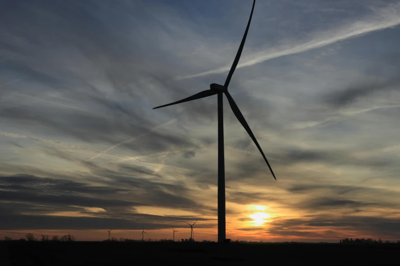 a wind turbine in a field at sunset, by Joe Stefanelli, pexels contest winner, slight overcast weather, nd 6, a green, posed