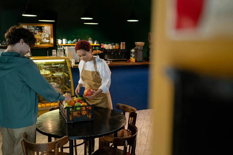 a couple of women standing next to each other at a table, by Julia Pishtar, pexels contest winner, convenience store, lady using yellow dress, aussie baristas, an escape room in a small