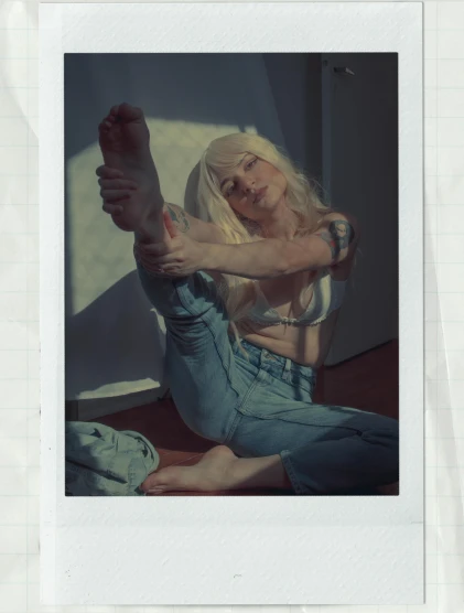 a woman sitting on the floor with her legs crossed, a polaroid photo, inspired by Elsa Bleda, ava max, with arms up, anna nikonova aka newmilky, sunfaded