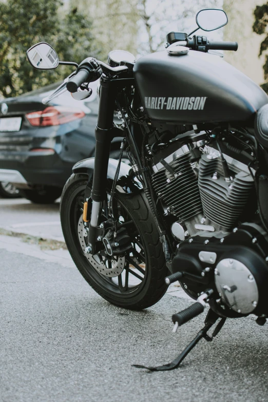 a black motorcycle parked on the side of the road, pexels contest winner, photorealism, close up shot from the side, low quality photo, 🚿🗝📝, harley davidson