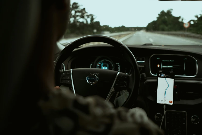 a man driving a car with a cell phone in his hand, by Carey Morris, pexels, realism, square, inside a grand, directions, hunting