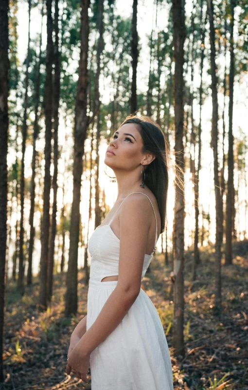 a woman in a white dress standing in a forest, by Robbie Trevino, golden hour 4k, low quality photo, in front of white back drop, half body photo