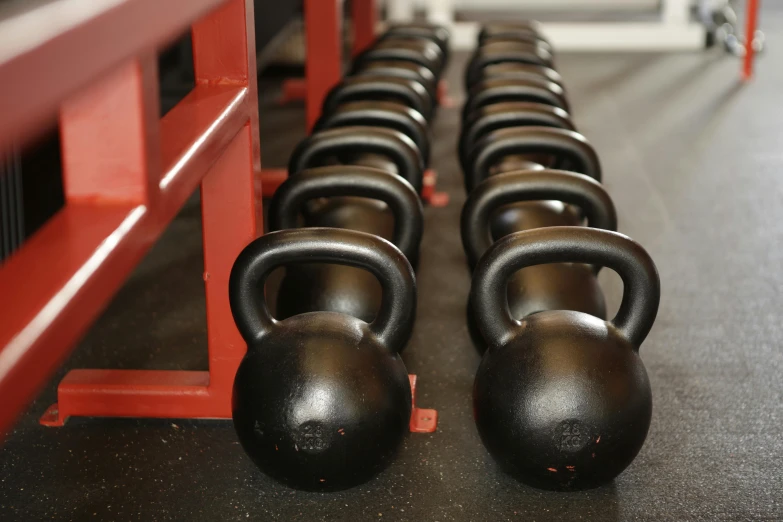 a row of kettlebells lined up in a gym, a portrait, by Tom Bonson, private press, black and red scheme, small