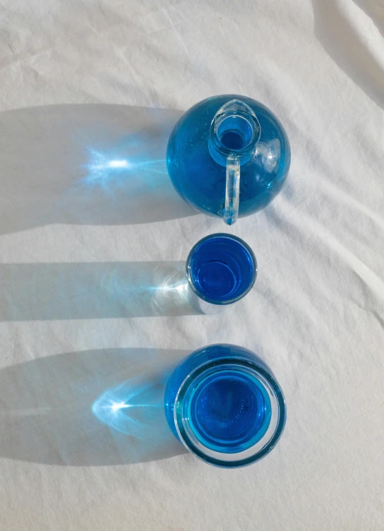 three water bottles sitting next to each other on a table, a still life, reddit, vibrant blue, teapots, translucent orbs, detailed product image