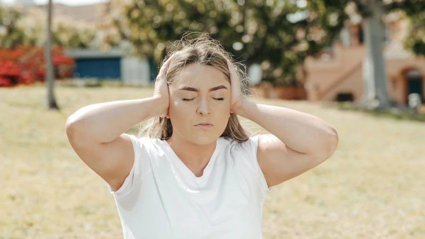 a woman standing in a field with her hands on her head, trending on pexels, snoring, straya, two small horn on the head, swollen muscles