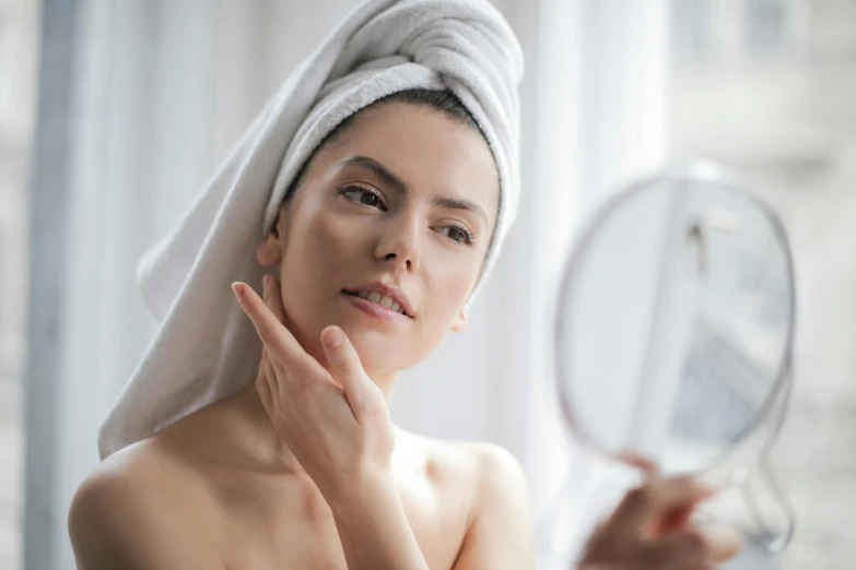 a woman with a towel on her head looking in a mirror, angular jawline, amanda lilleston, natural and organic and flowing, having a good time