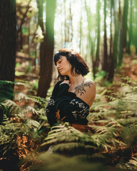 a woman sitting in the middle of a forest, photograph of a sleeve tattoo, non binary model, fern, trending photo