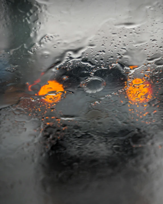 a car driving in the rain on a rainy day, an album cover, unsplash, orange halo, square, trending photo, pareidolia