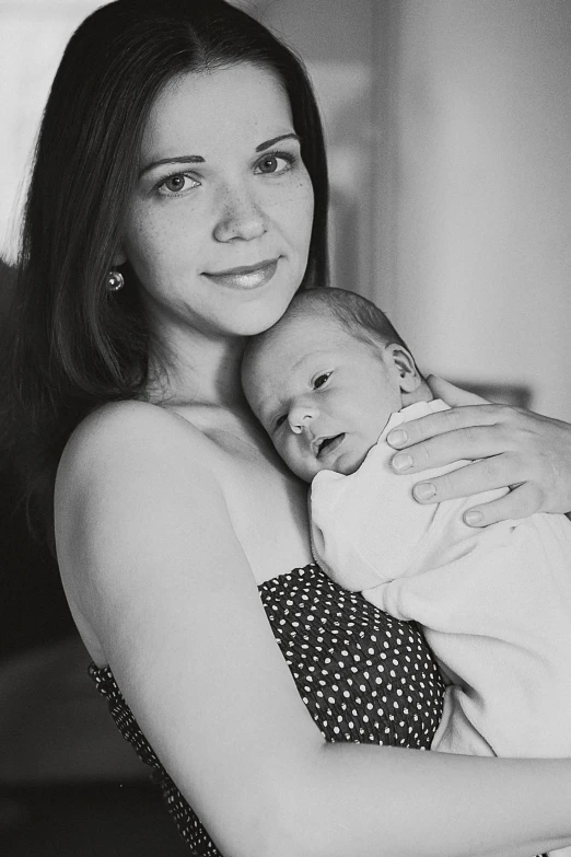 a woman holding a baby in her arms, a black and white photo, by Silvia Dimitrova, flickr, high quality portrait photoshoot, beutiful!, indoor picture, 2717433015