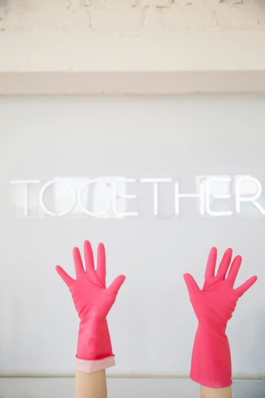 a couple of pink gloves sitting on top of a table, by Julia Pishtar, trending on unsplash, lettering clean, holding each other hands, photographed for reuters, teamlab