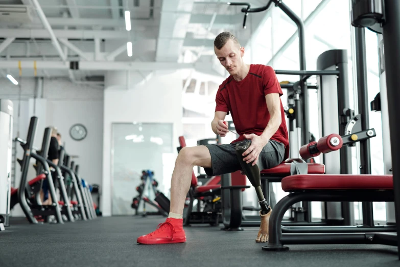 a man sitting on a bench in a gym, prosthetic, healthcare, digital still, high-quality photo