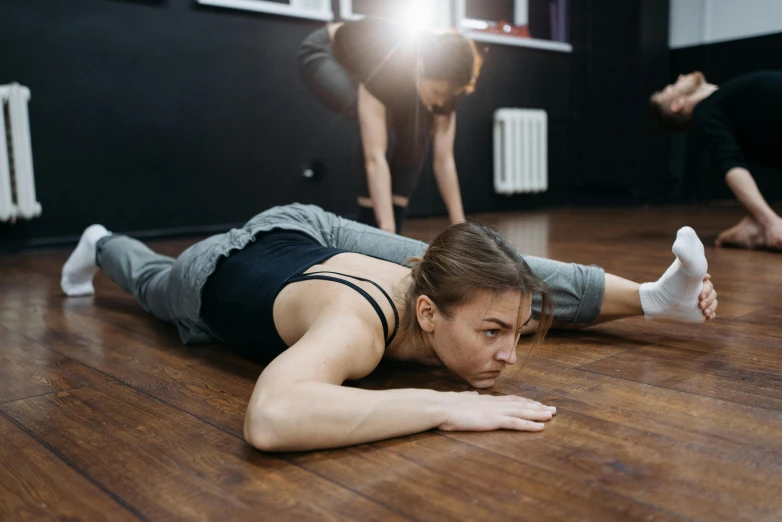 a woman laying on the floor in a dance studio, trending on pexels, quadruped, woman holding another woman, profile image, sweating