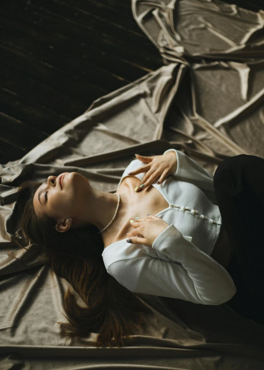 a beautiful woman laying on top of a bed, inspired by Elsa Bleda, pexels contest winner, renaissance, folds of fabric, grim fashion model looking up, open v chest clothes, on a velvet table cloth
