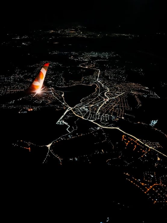 an airplane flying over a city at night, by Sam Black, pexels contest winner, hurufiyya, red sprites in the atmosphere, bird\'s eye view, taken on iphone 1 3 pro, hyperdetailed photo