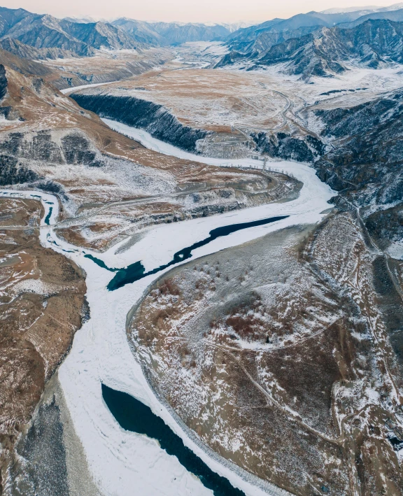 a river running through a snow covered valley, pexels contest winner, hurufiyya, erosion algorithm landscape, air shot, thumbnail, multiple stories