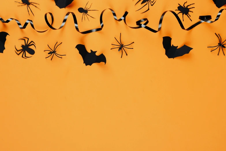 a group of halloween decorations hanging on a wall, trending on pexels, visual art, wide ribbons, background image, tarantulas, caramel