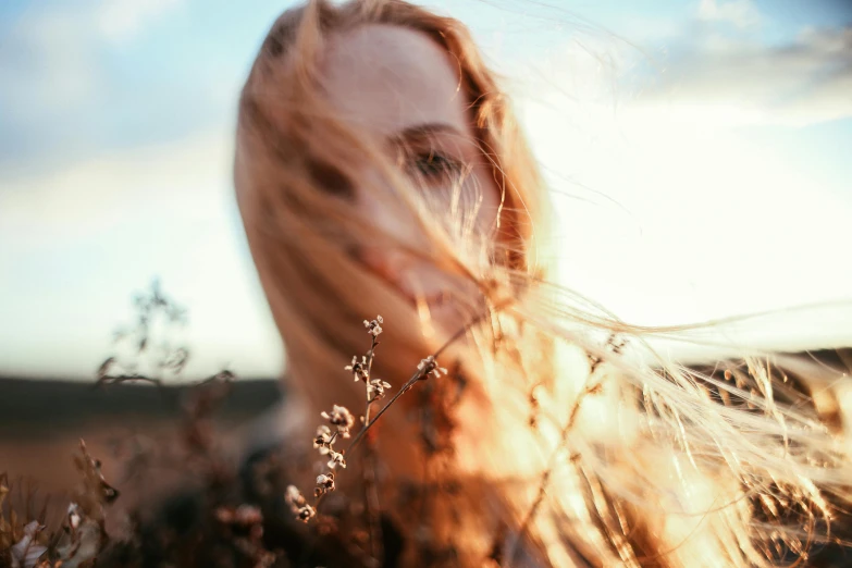 a woman standing in a field with her hair blowing in the wind, pexels contest winner, close up of a blonde woman, close - up on face, instagram post, unfocused