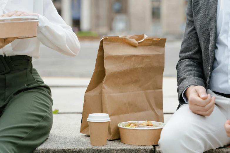 a couple of people sitting next to each other, by Nina Hamnett, trending on pexels, renaissance, logo for lunch delivery, brown paper, people outside walk, ready to eat