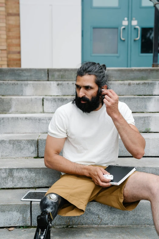 a man sitting on steps talking on a cell phone, trending on pexels, renaissance, chest hair, at college, curled beard, aboriginal australian hipster