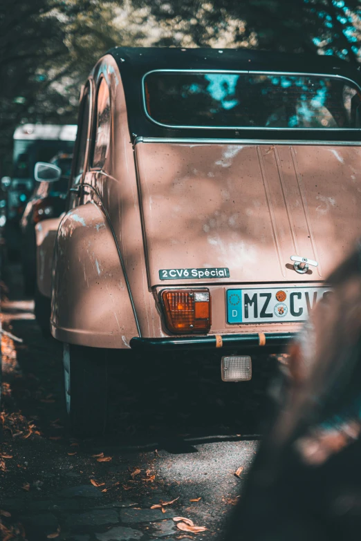 an old car parked on the side of the road, by Adam Marczyński, pexels contest winner, renaissance, brown and pink color scheme, close-up shot from behind, french, square