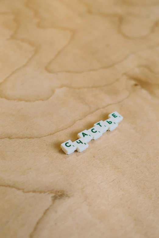 a close up of a scrabble on a table, a macro photograph, by Grace Clements, unsplash, visual art, white rocks made of bone, in claymation, carapace, minimalistic logo