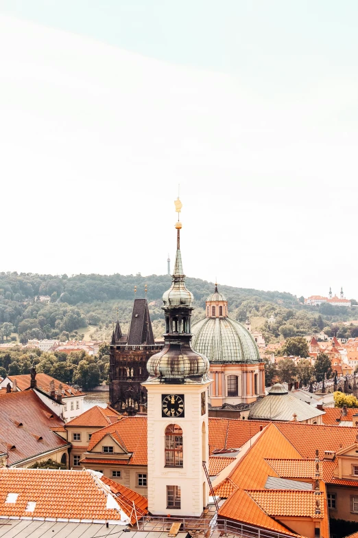 a view of a city from the top of a building, by Matija Jama, unsplash contest winner, baroque, orange roof, lead - covered spire, hills in the background, ivory and copper
