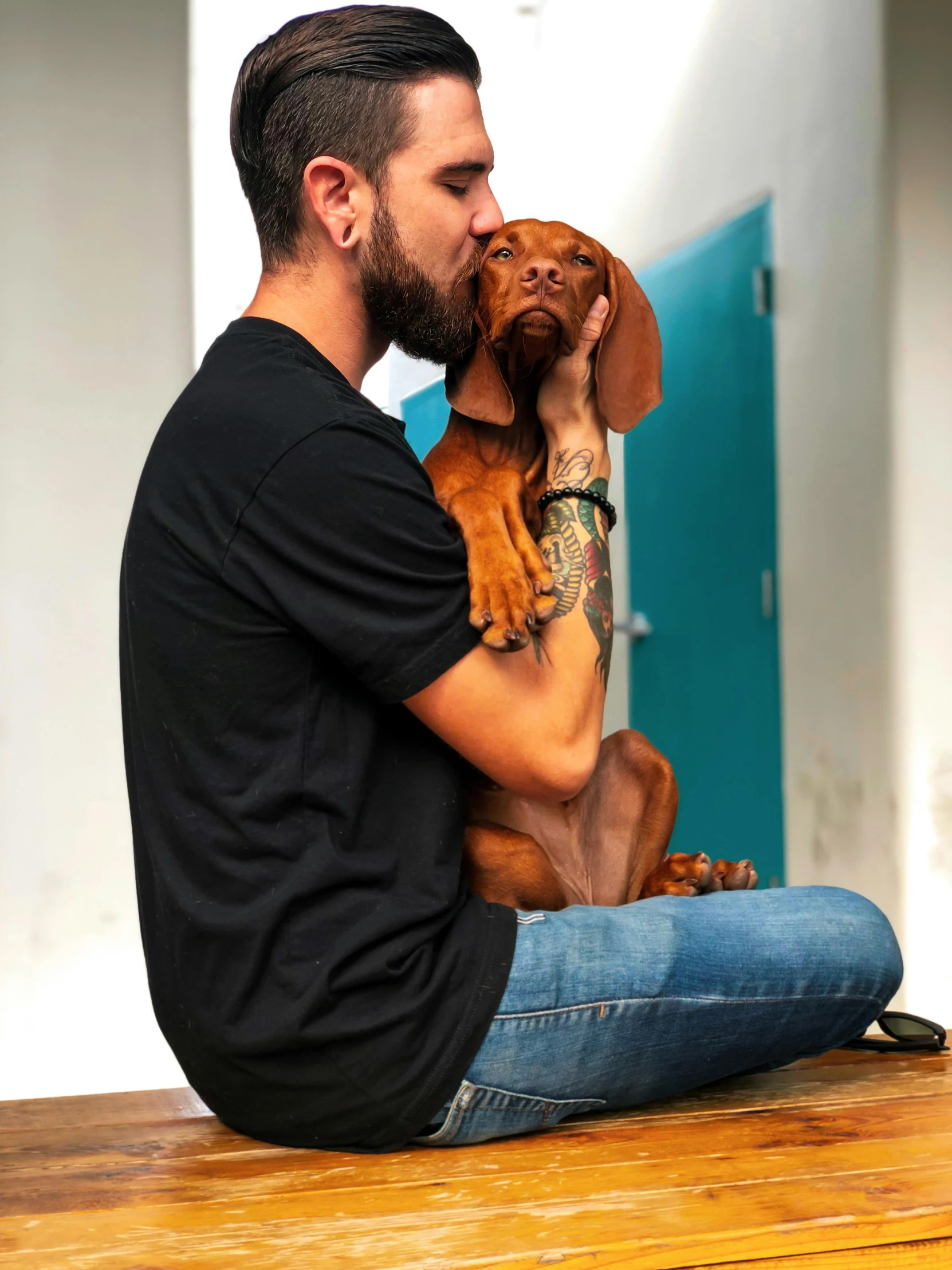 a man sitting on a bench holding a dog, profile image, large)}], indoor picture, embrace