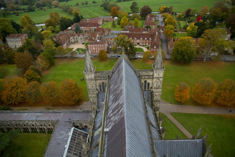 an aerial view of a church with a green field in the background, by Alison Debenham, shutterstock, cathedral ceiling, autumnal, as seen from the canopy, spire